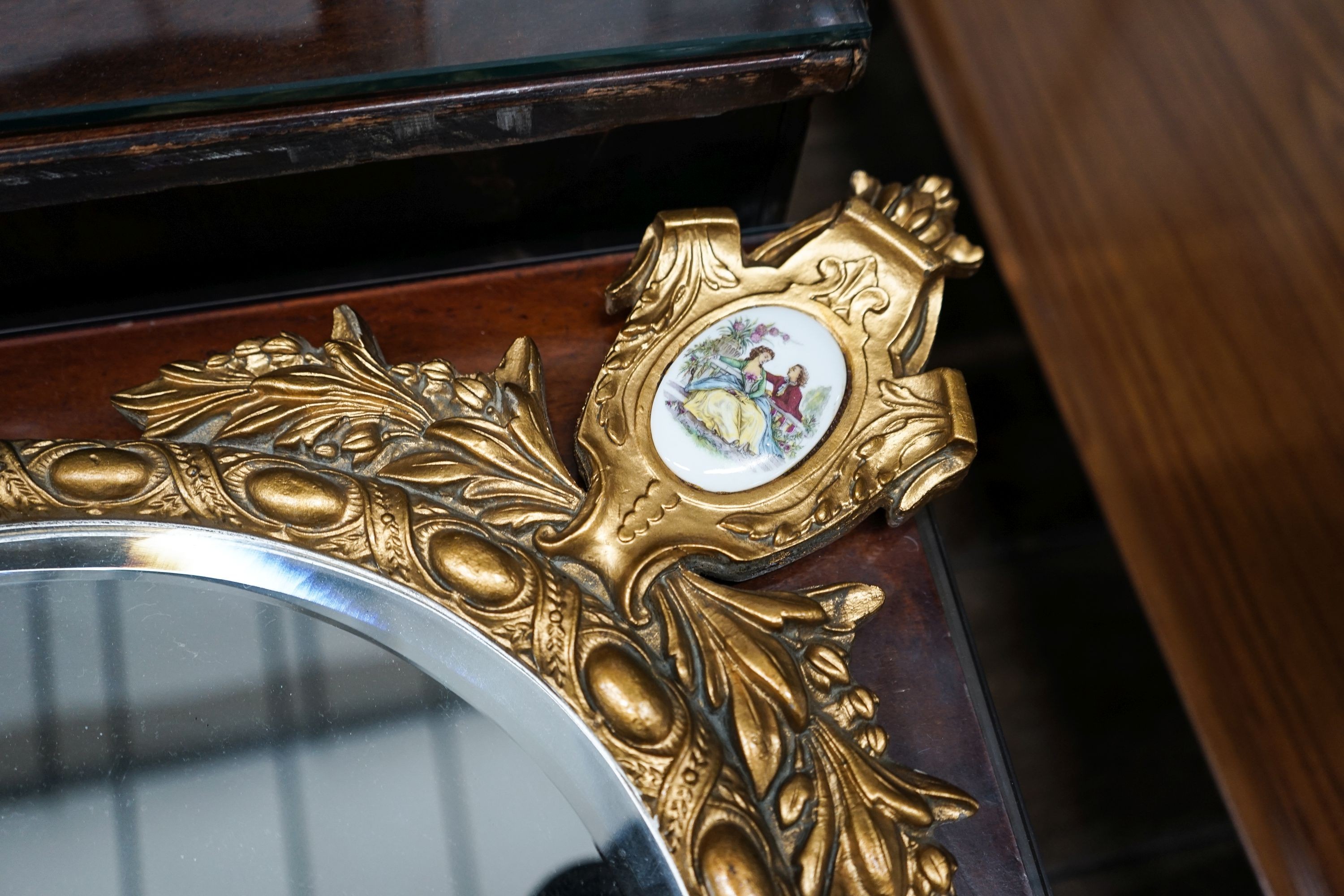 A pair of oval gilt framed wall mirrors inset porcelain plaques, width 42cm, height 78cm